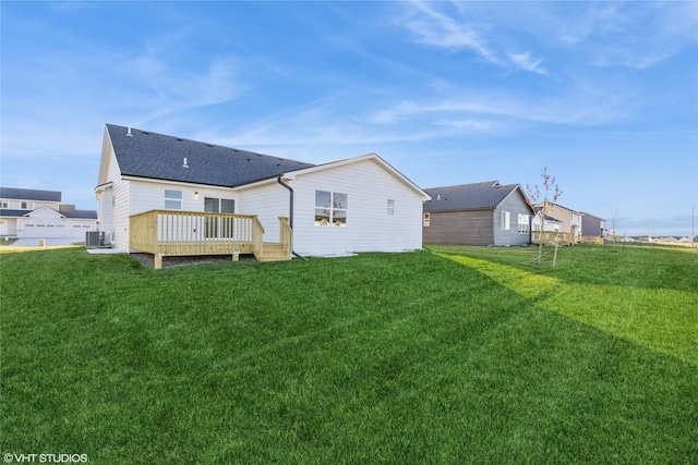 rear view of property featuring cooling unit, a deck, and a yard