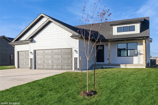 view of front of property featuring central AC unit, a garage, and a front lawn