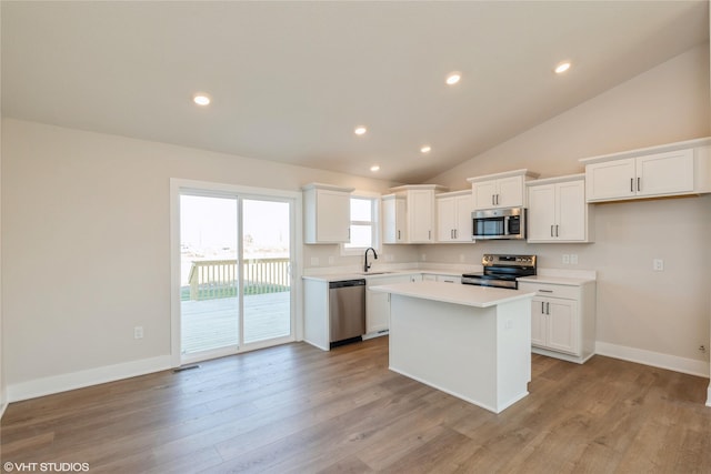 kitchen featuring white cabinets, a center island, light wood-type flooring, and appliances with stainless steel finishes