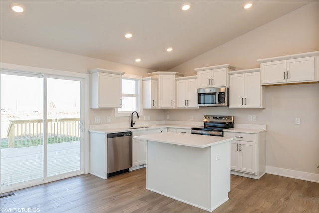 kitchen with white cabinets, sink, a center island, and appliances with stainless steel finishes