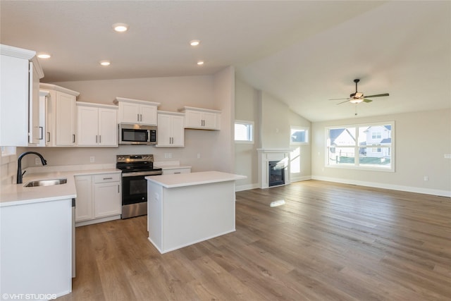 kitchen with a center island, lofted ceiling, sink, and appliances with stainless steel finishes