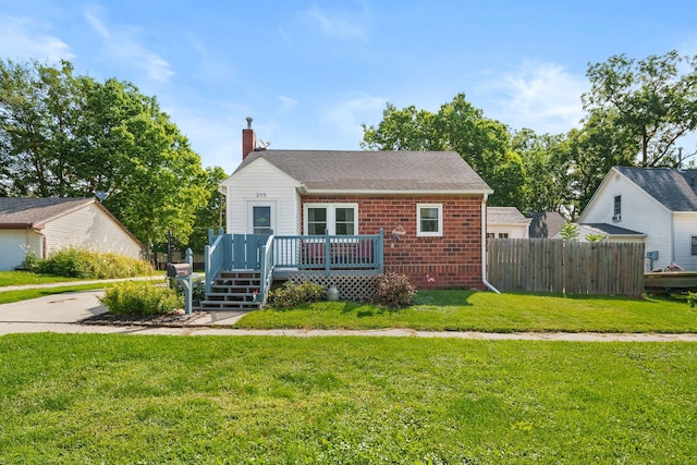 bungalow-style home with a front lawn and a deck