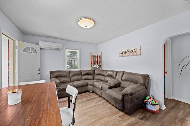 living room featuring light hardwood / wood-style floors and a wall unit AC