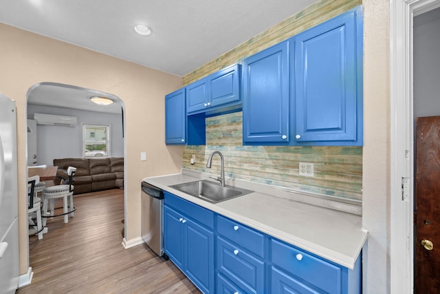 kitchen with dishwasher, decorative backsplash, sink, light wood-type flooring, and a wall mounted air conditioner