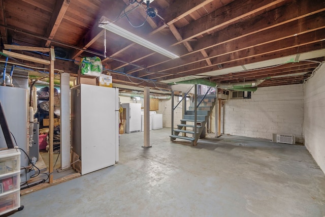 basement featuring washer / clothes dryer and white refrigerator