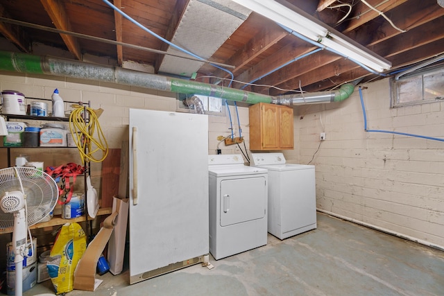 basement with washer and dryer and white refrigerator