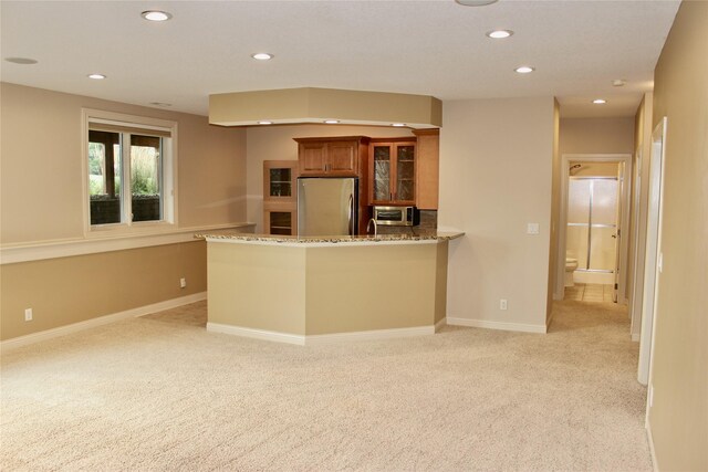 kitchen with kitchen peninsula, stainless steel appliances, and light colored carpet