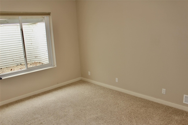 carpeted spare room featuring visible vents and baseboards