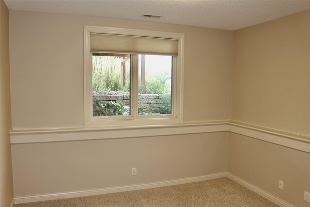 carpeted empty room with a textured ceiling