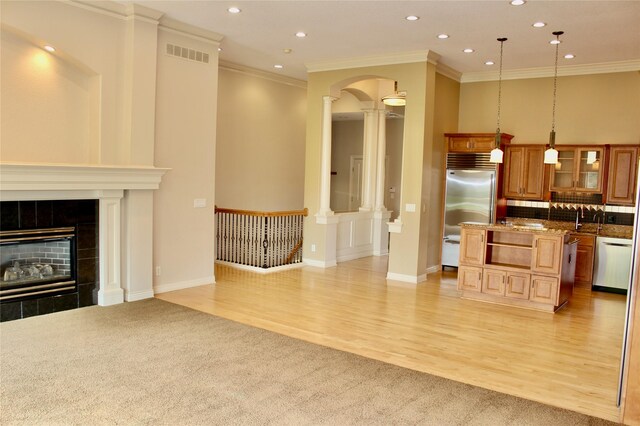 living room featuring crown molding, a tiled fireplace, and light hardwood / wood-style flooring