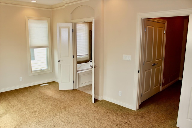 unfurnished bedroom featuring carpet floors, ornamental molding, and baseboards