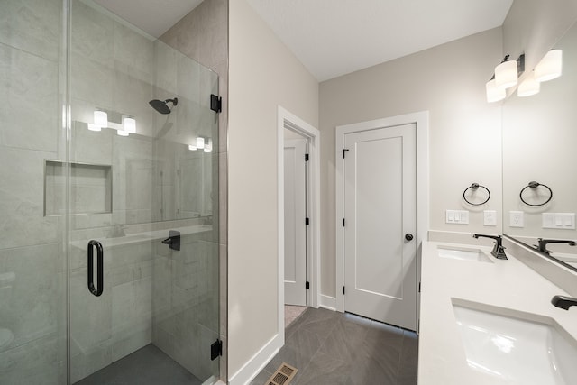 bathroom featuring tile patterned flooring, vanity, and a shower with door