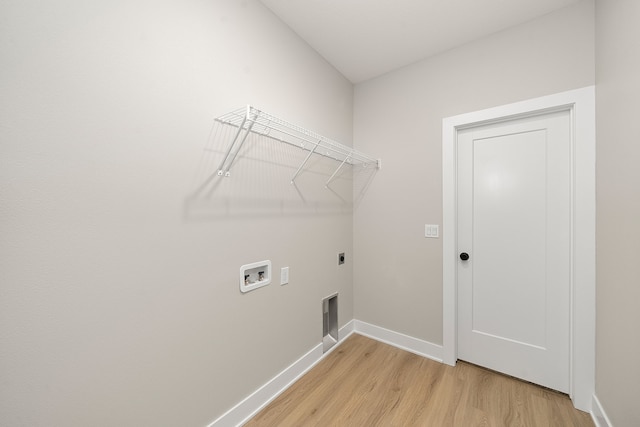 clothes washing area featuring washer hookup, hookup for an electric dryer, and light hardwood / wood-style flooring