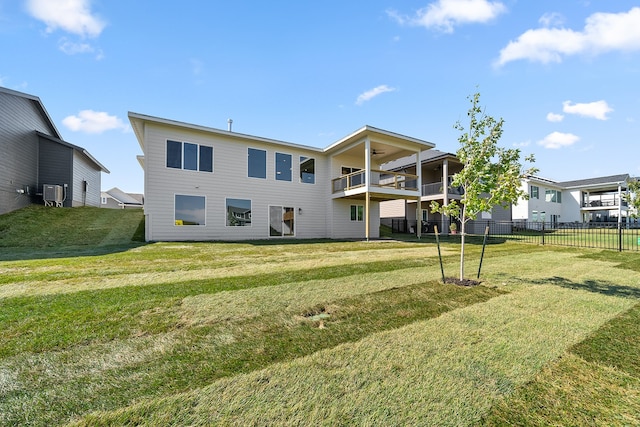 back of house with a balcony and a lawn