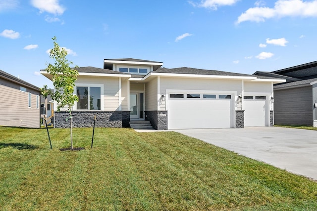 prairie-style house featuring a front lawn and a garage