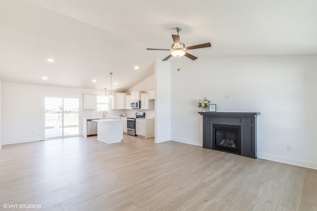 unfurnished living room featuring light hardwood / wood-style floors, high vaulted ceiling, sink, and ceiling fan