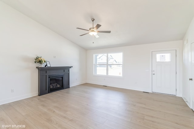 unfurnished living room featuring light wood-type flooring, vaulted ceiling, and ceiling fan