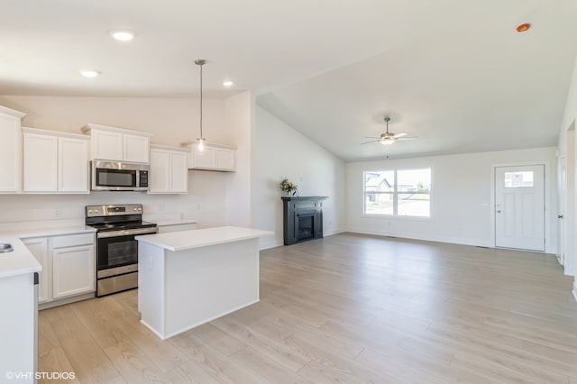 kitchen with a center island, light wood-type flooring, appliances with stainless steel finishes, ceiling fan, and white cabinetry