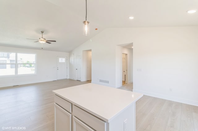 kitchen with a kitchen island, vaulted ceiling, light wood-type flooring, and hanging light fixtures