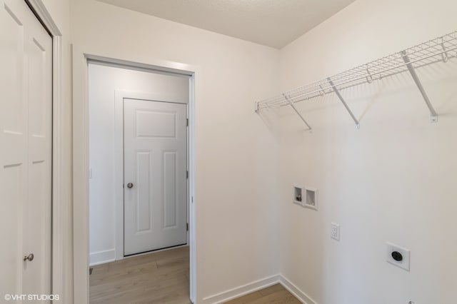 washroom featuring light hardwood / wood-style flooring, hookup for a washing machine, and hookup for an electric dryer