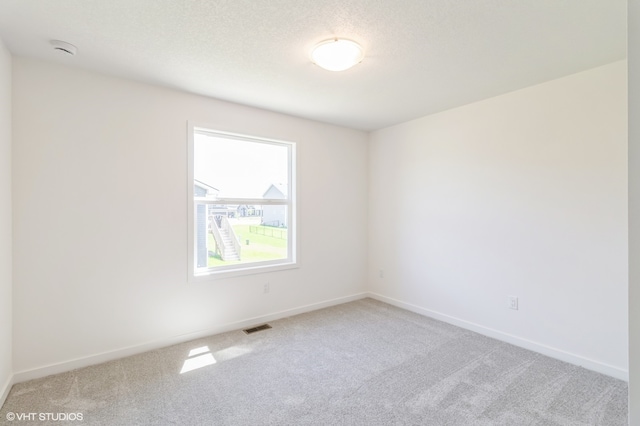 carpeted spare room featuring a textured ceiling