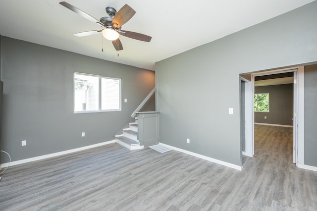 spare room with a wealth of natural light, ceiling fan, and light hardwood / wood-style flooring