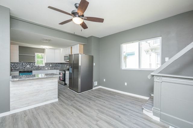 kitchen with light hardwood / wood-style flooring, ceiling fan, white cabinetry, backsplash, and stainless steel appliances