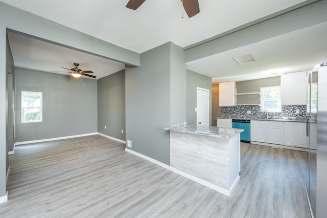 kitchen featuring appliances with stainless steel finishes, white cabinets, backsplash, and light hardwood / wood-style flooring