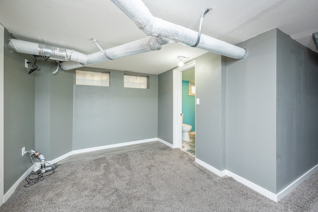 basement with carpet flooring and a textured ceiling