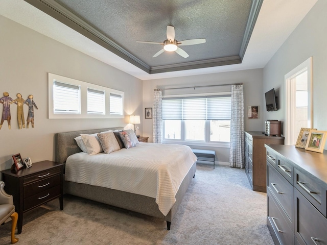 carpeted bedroom with a raised ceiling, crown molding, a textured ceiling, and ceiling fan