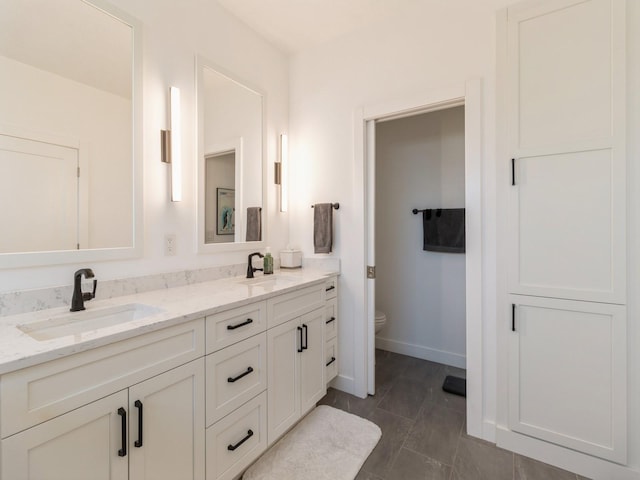 bathroom featuring vanity, tile patterned floors, and toilet