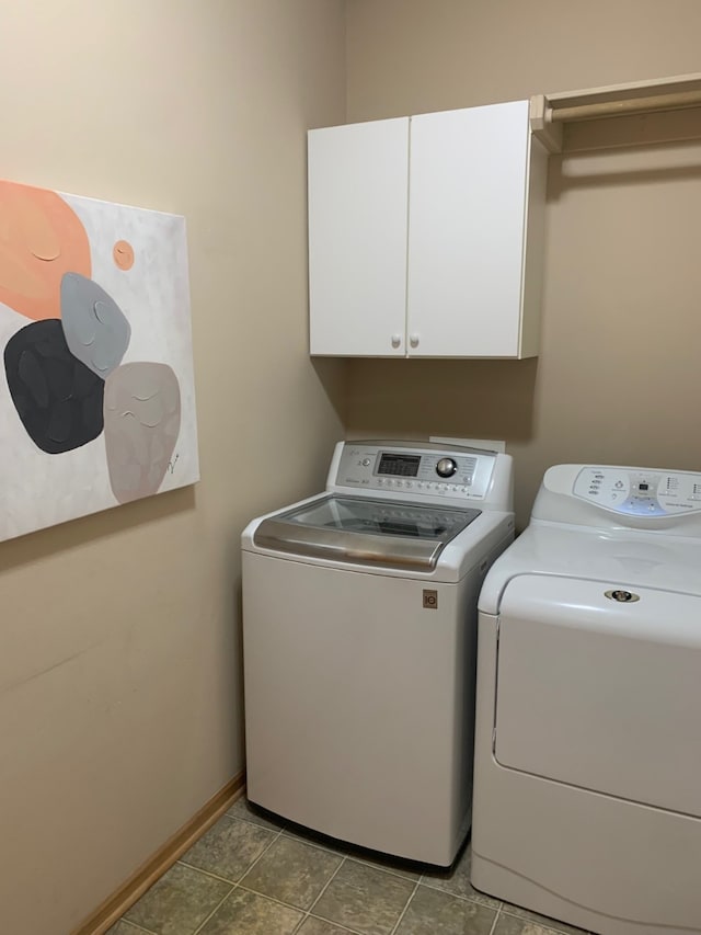 washroom with washer and clothes dryer and cabinets