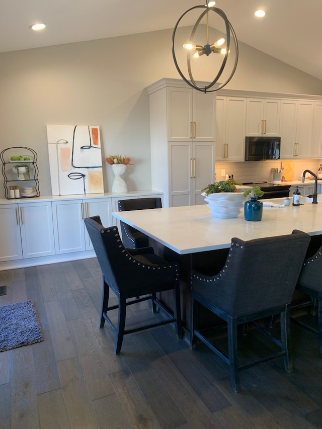 dining room featuring lofted ceiling, dark hardwood / wood-style flooring, and a notable chandelier