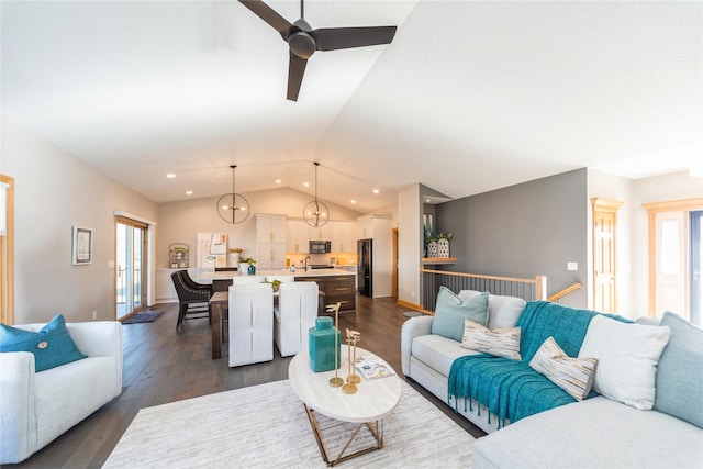 living room with a healthy amount of sunlight, lofted ceiling, and dark hardwood / wood-style flooring