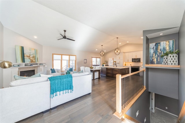 living room featuring vaulted ceiling, sink, ceiling fan, and dark hardwood / wood-style flooring