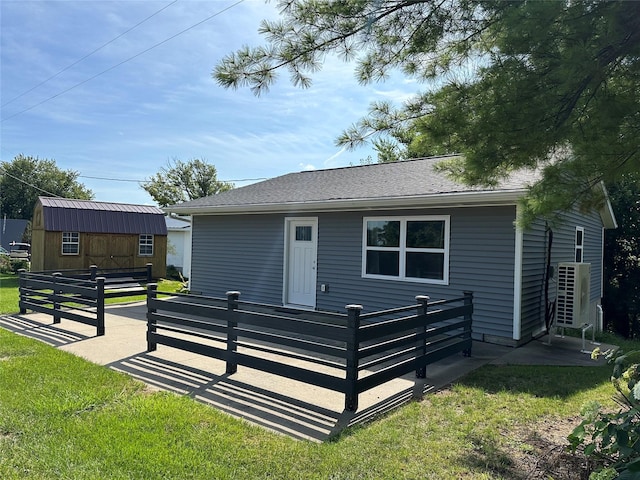 single story home with an outdoor structure, fence, a front yard, and a patio area