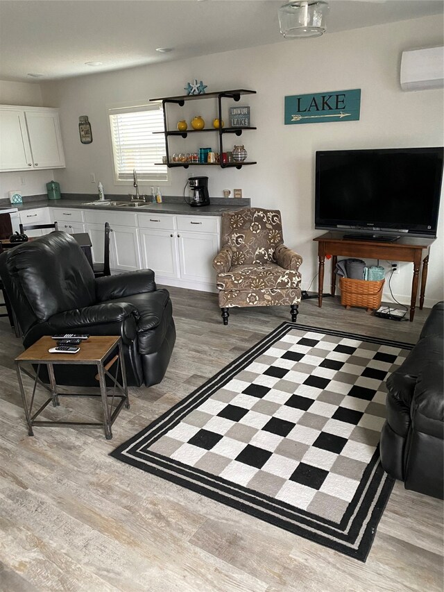 living area featuring light wood-style flooring, bar area, and a wall mounted air conditioner