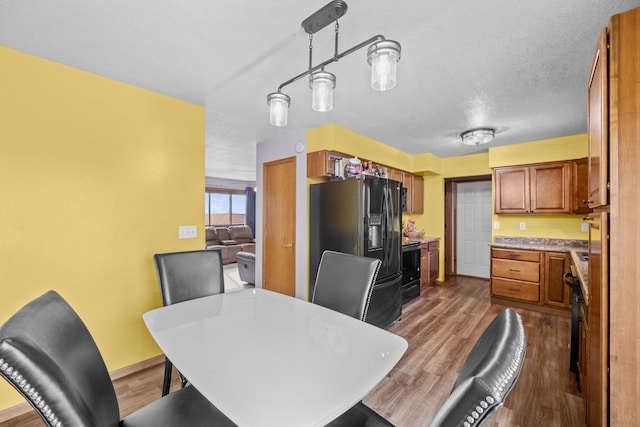 dining room featuring hardwood / wood-style flooring and a textured ceiling