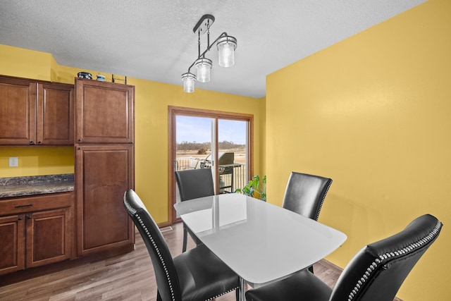 dining room featuring hardwood / wood-style flooring and a textured ceiling