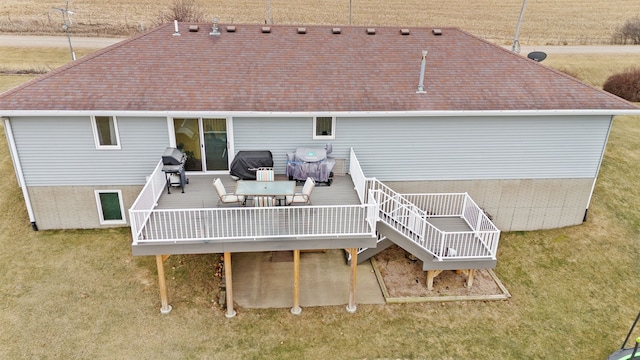 back of house featuring a wooden deck and a lawn