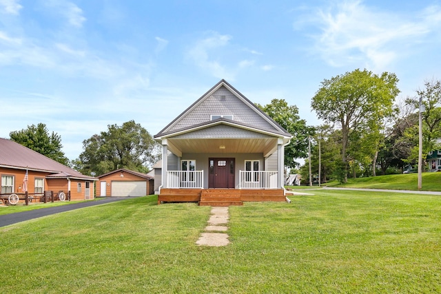 view of front facade with an outdoor structure, a front yard, a porch, and a garage