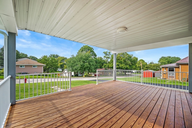 deck featuring a storage shed and a yard