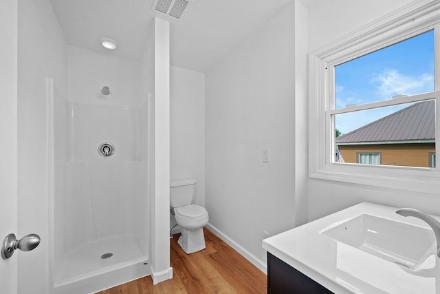 bathroom featuring vanity, a shower, toilet, and hardwood / wood-style flooring