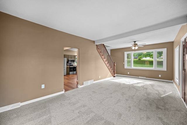 unfurnished living room with ceiling fan and light colored carpet