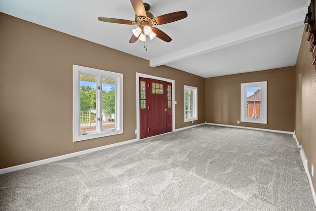 foyer entrance with beam ceiling, ceiling fan, and carpet flooring