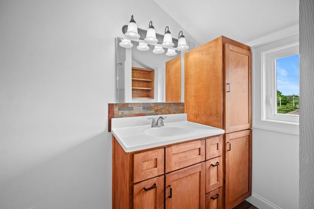 bathroom with vanity, backsplash, and vaulted ceiling