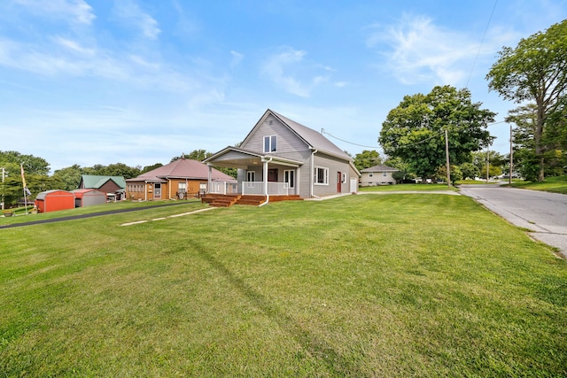 view of front facade featuring a front lawn, covered porch, and an outdoor structure