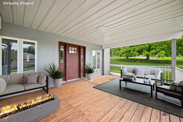 deck with an outdoor living space with a fire pit