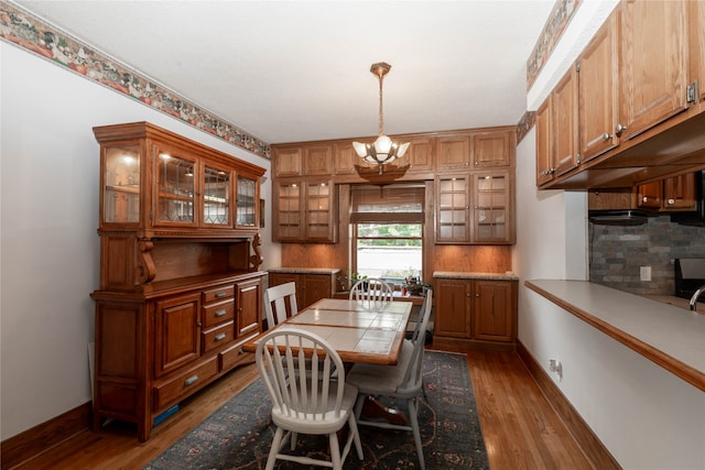 dining space featuring hardwood / wood-style flooring and an inviting chandelier