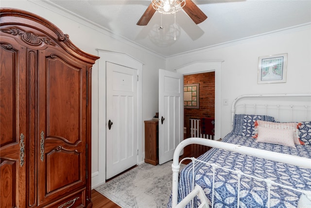 bedroom with ceiling fan, hardwood / wood-style floors, and ornamental molding